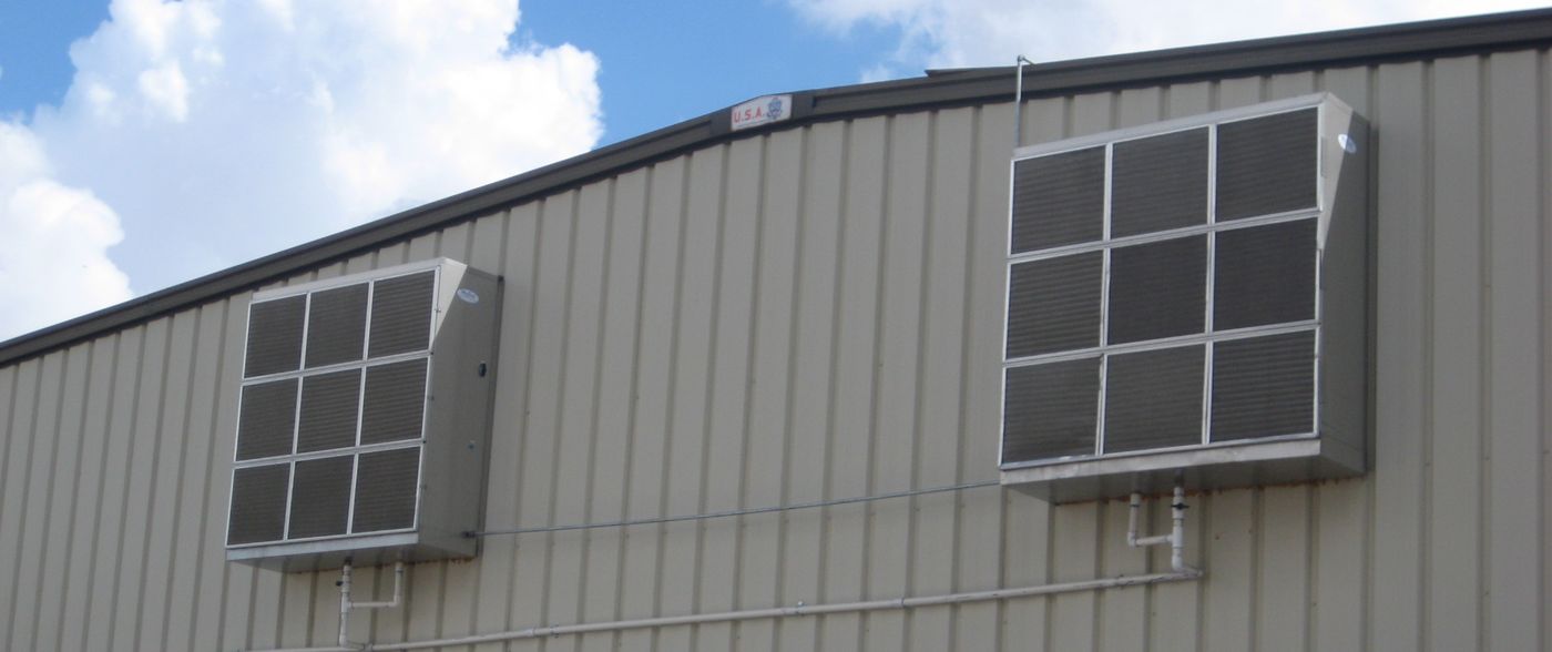 Two HV 50 evaporative coolers mounted high on the outside wall of a metal industrial building